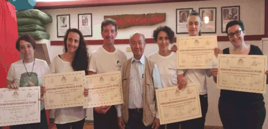 Gruppo di neo riflessologi al corso di Riflessologia plantare metodo On Zon Su mostrano i diplomi con la presenza del Maestro Ming